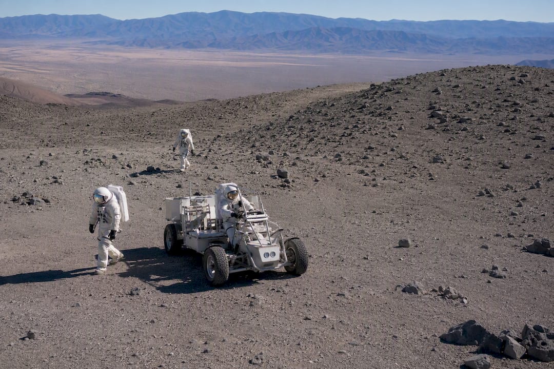 Astronautai lauke treniruojasi su Mėnulio roveryje dėvimais kostiumais